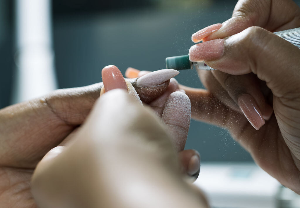 Close-up of a nail technician at Lapis Lazuli Beauty Bar finishing a client's nails